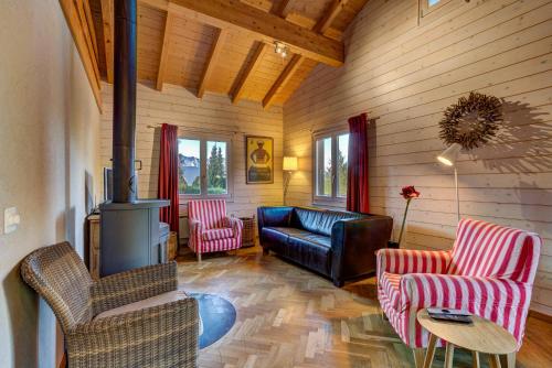 a living room with a couch and chairs and a fireplace at Chalet du Bourg in La Tzoumaz