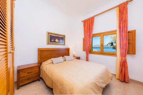 a bedroom with a bed and a window at Sa Marina in Alcudia