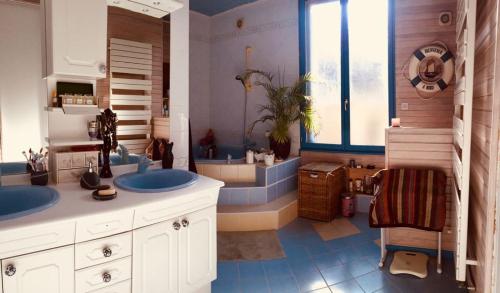 ein großes Badezimmer mit zwei Waschbecken und einer Badewanne in der Unterkunft Superbe maison de caractère, de 1 à 9 couchages in Sainte-Maure-de-Touraine