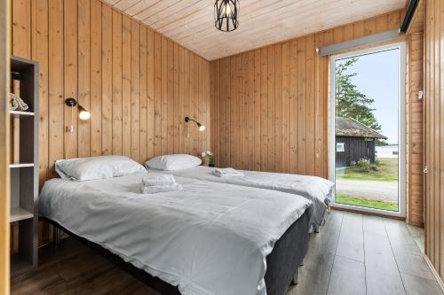 um quarto com 2 camas e uma grande janela em Topcamp Onsakervika - Tyrifjorden em Svensrud
