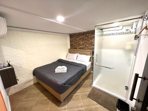 Un dormitorio pequeño con una cama y una ducha. en Great House 99, en Bangkok
