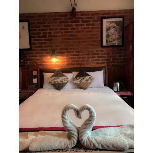- 2 serviettes en forme de cœur sur un lit dans l'établissement Shiva Guest House 2, à Bhaktapur