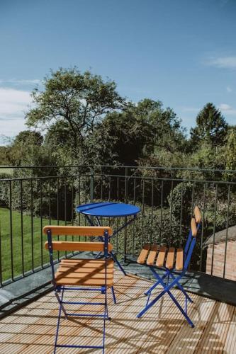 two chairs and a table on a deck with a fence at The Barn in Nottingham