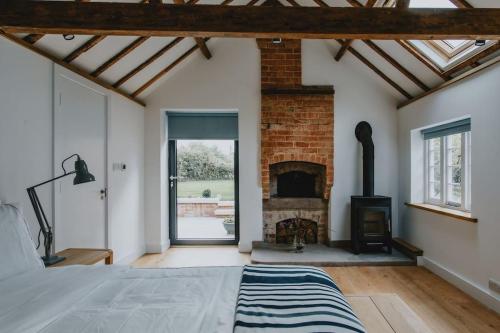 a bedroom with a fireplace and a bed in a room at The Barn in Nottingham