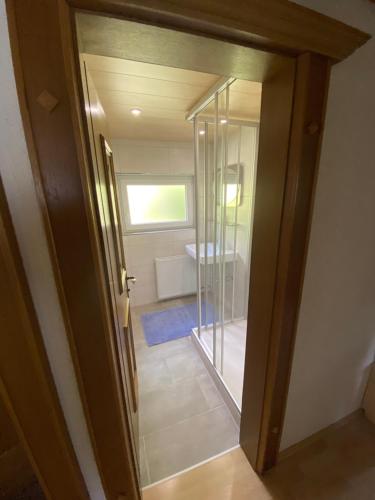 a bathroom with a glass door leading to a tub at Ferienhaus Gandle in Kappl