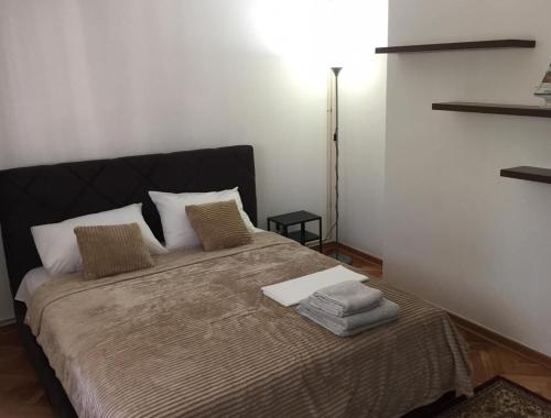 - une chambre avec un lit doté d'oreillers et d'une lampe dans l'établissement 2Anna Apartments, à Surčin
