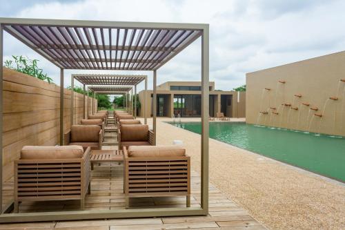 a row of lounge chairs and a swimming pool at Life At REPOSE- Lake Villas Resort & Club in Chor Warodra
