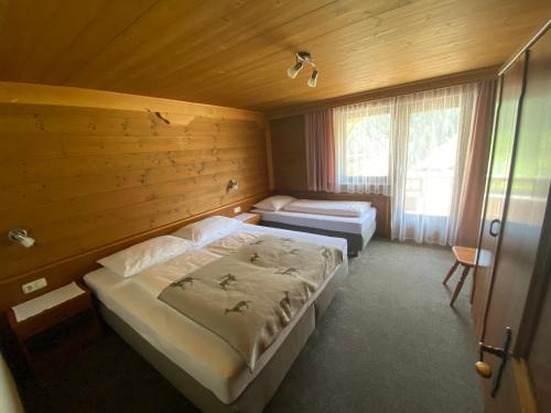 a bedroom with two beds in a wooden room at Ferienhaus Gandle in Kappl