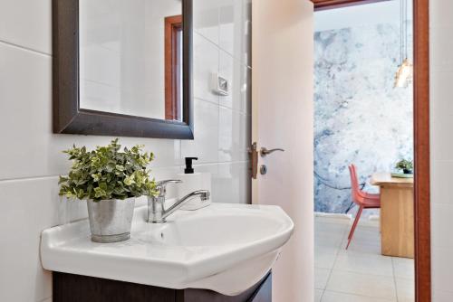uma casa de banho com um lavatório e um vaso de plantas em Design Apartments em Tel Aviv