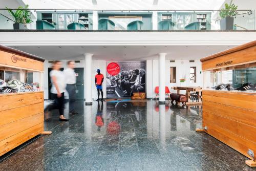 a room with people standing in a building with a table at Hotel Akazienhaus in Herzogenaurach