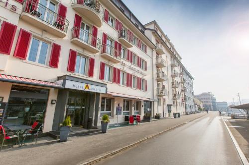 an empty street next to a building with red windows at Hotel Amaris in Olten