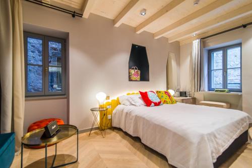 a bedroom with a bed and a table and windows at The Melegran in Rovinj