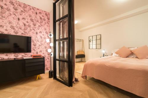 a bedroom with a large bed and a tv at The Melegran in Rovinj
