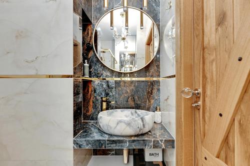 uma casa de banho com um lavatório em mármore e um espelho. em Sopot Beach & Park Penthouse by Downtown Apartments em Sopot