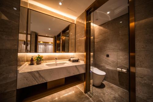 uma casa de banho com um lavatório e um WC em Howard Johnson by Wyndham Lanting Hotel Ningbo em Ningbo