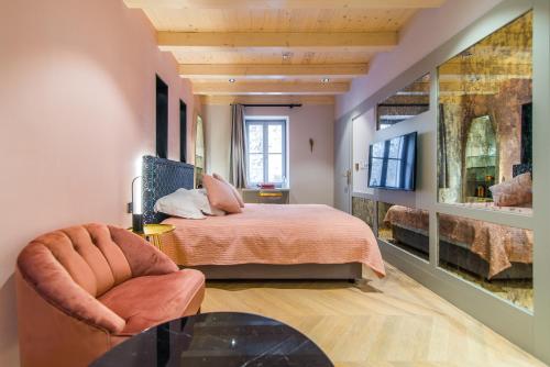 a bedroom with a bed and a chair and a table at The Melegran in Rovinj