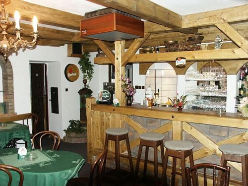 a restaurant with a bar with stools in a room at Penzion St. Florian Příbor in Příbor