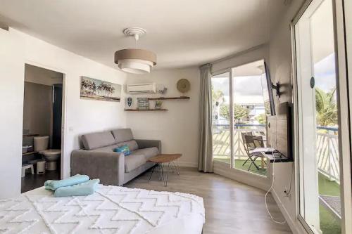 un soggiorno con divano e un soggiorno con finestra. di Archipel - Cocon d'une architecte en Guadeloupe a Saint-François