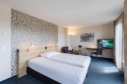 Oberentfeldenにあるアーラウ　ウェスト　スイス　クオリティ　ホテルのベッドとデスクが備わるホテルルームです。