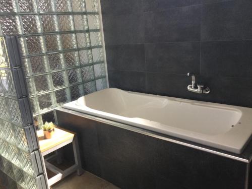 a bath tub in a bathroom with a window at Akira villa in Port Louis