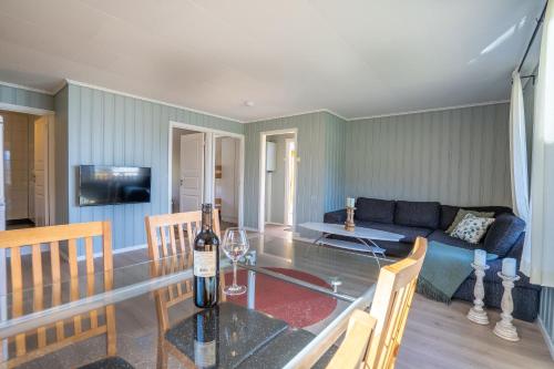 Topcamp Havblikk - Helgeland في Nesna: غرفة معيشة مع طاولة مع زجاجة من النبيذ