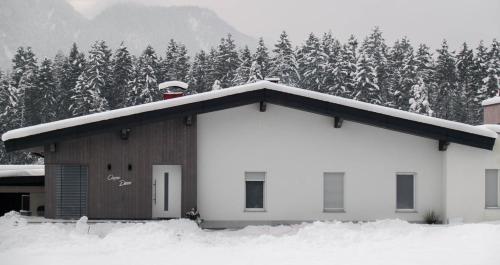a man standing on the roof of a house in the snow at Apartment Carpe Diem in Kramsach