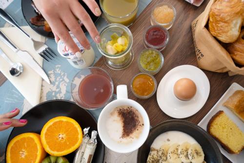 a table with a bunch of different types of breakfast foods at Hôtel Jules Verne Biarritz in Biarritz
