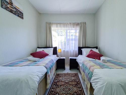 2 camas individuais num quarto com uma janela em House of Grace Apt em East London