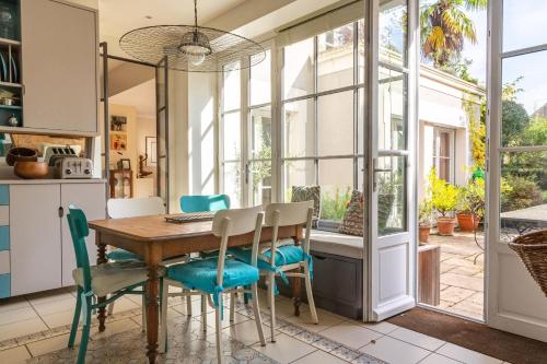 une cuisine et une salle à manger avec une table et des chaises dans l'établissement Belle maison contemporaine avec piscine, à Nantes