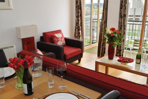 a living room with a red couch and a table at Highland Apartments by Mansley in Inverness