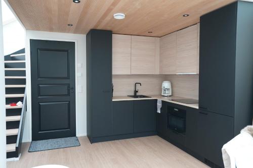 uma cozinha com armários pretos e uma porta preta em Levillas Utsunkulma 10B em Levi
