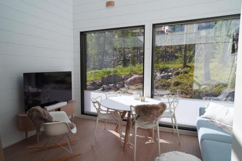 a living room with a table and chairs and a tv at Levillas Utsunkulma 10B in Levi