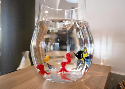 a glass vase with fish in it on a table at Hôtel Jules Verne Biarritz in Biarritz