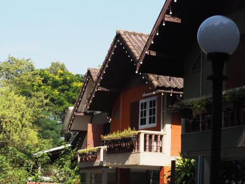 a house with a balcony and a street light at Chomklong Experience in Pak Chong