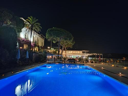 a large blue swimming pool at night at Hotel Roger de Flor by Seleqtta in Lloret de Mar