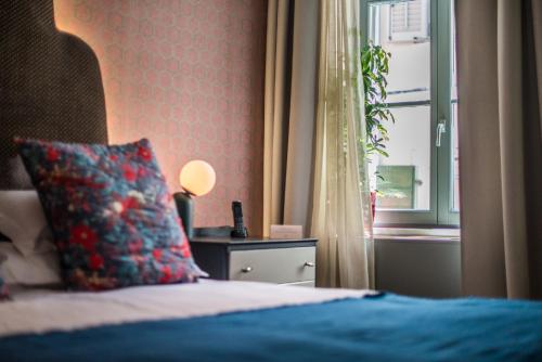 a bedroom with a bed with a pillow and a window at The Melegran in Rovinj