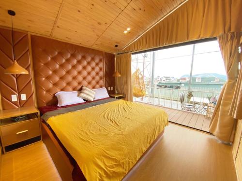 a bedroom with a yellow bed and a balcony at Ngọc Nguyên Homestay in Da Lat