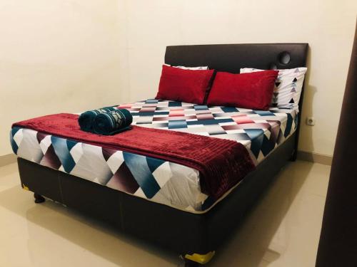 ein Bett mit einer bunten Decke und Kissen darauf in der Unterkunft Calliandra Homestay in Banyuwangi
