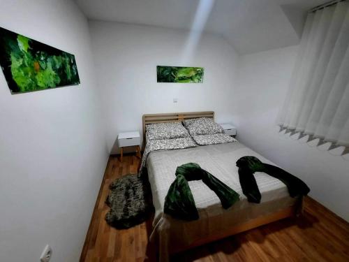 a bedroom with a bed with green pants on it at Vrnačka Banja Apartman Paeonia in Vrnjci