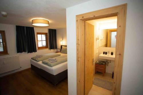 1 dormitorio con 1 cama y baño con lavamanos en Appartment Gamper Top 7 en Flirsch
