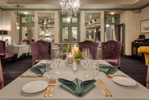 a dining room with a table with plates and glasses at Grand Palace Hotel - Small Luxury Hotels of the World in Rīga