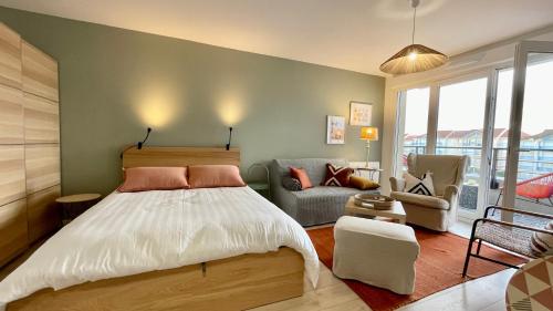 a bedroom with a bed and a living room at Studio Couleurs d'Opale in Stella-Plage