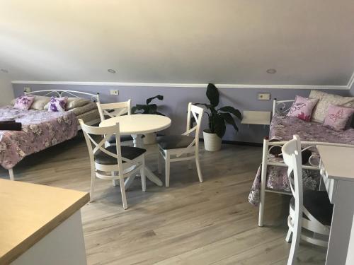 a room with two beds and a table and chairs at Villa Galicia in Berehove