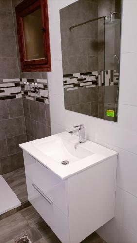 a bathroom with a white sink and a shower at Grace resident stúdió apartman in La Mata