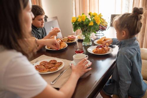 a group of people sitting at a table eating breakfast at KATERINA guest house in Kocherinovo