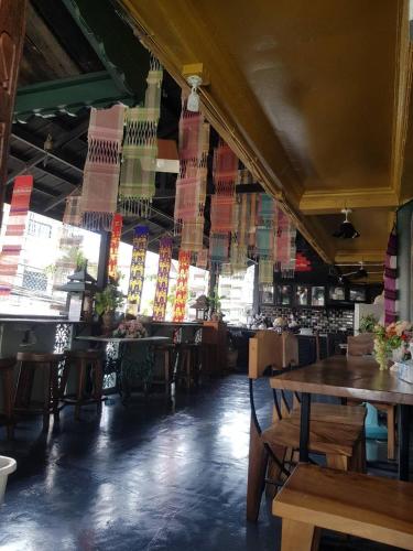 a restaurant with tables and chairs and colorful flags at Ma Guesthouse Chiang Mai in Chiang Mai