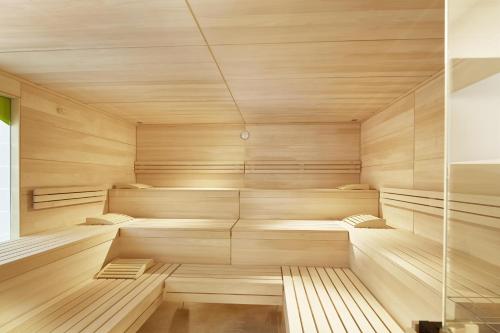 Elle comprend un sauna avec des murs en bois et du parquet. dans l'établissement keyone rooms Loisach, à Lermoos