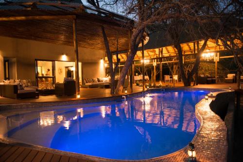 a large swimming pool in a resort at night at Moditlo River Lodge in Hoedspruit
