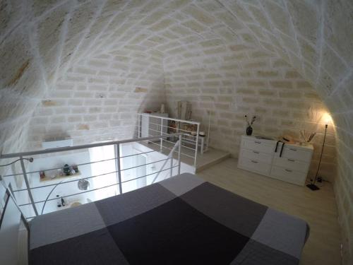 Pokój z łóżkiem i białą ceglaną ścianą w obiekcie La dolce casa - Puglia last minute w mieście Carovigno