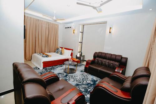 a living room with a couch and a bed at Inoga Luxury Hotel in Dodoma